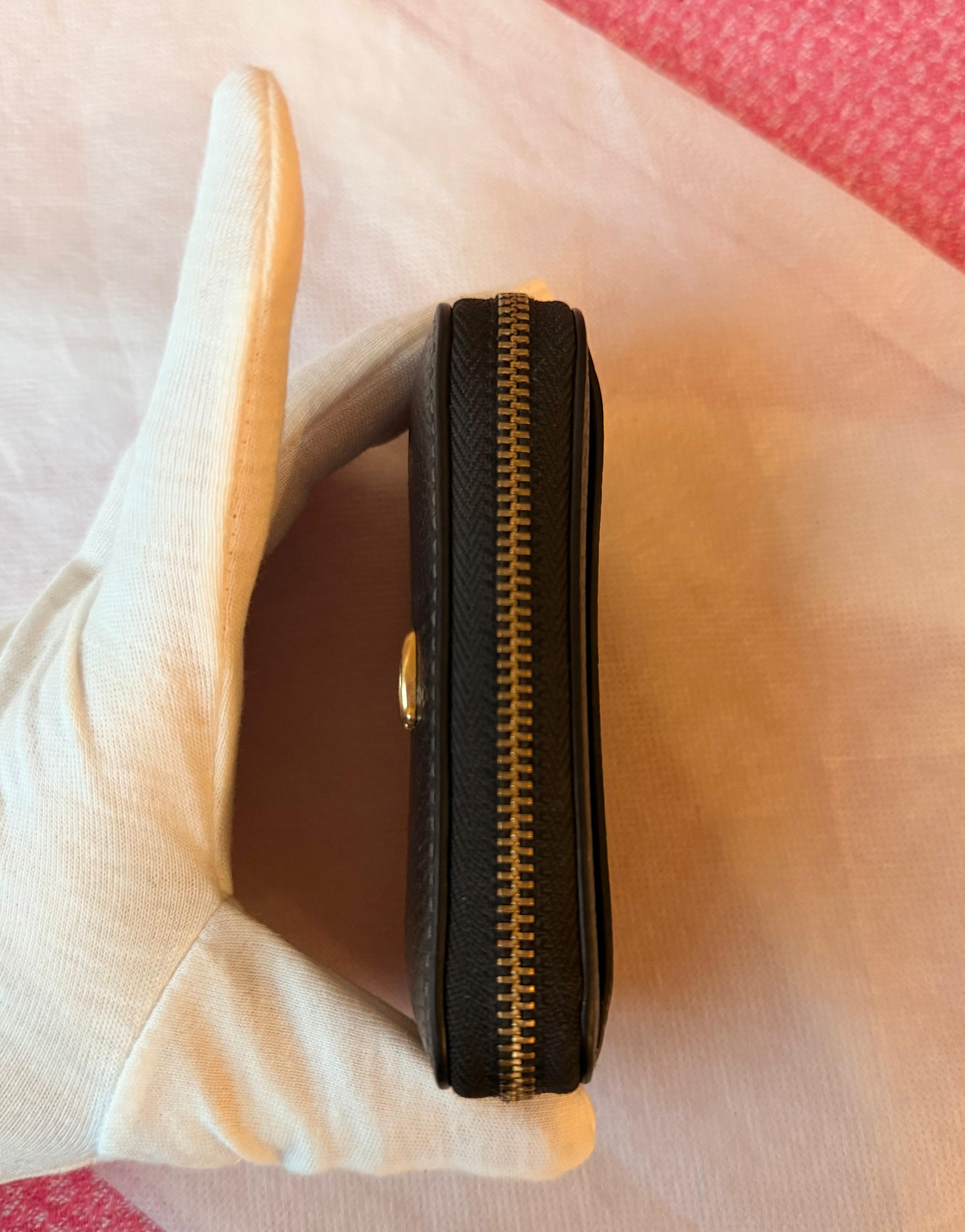 Coach small zip-around wallet black leather — detail closeup